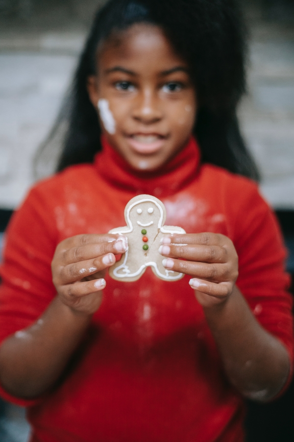 Girl holding up decorated gingerbread man